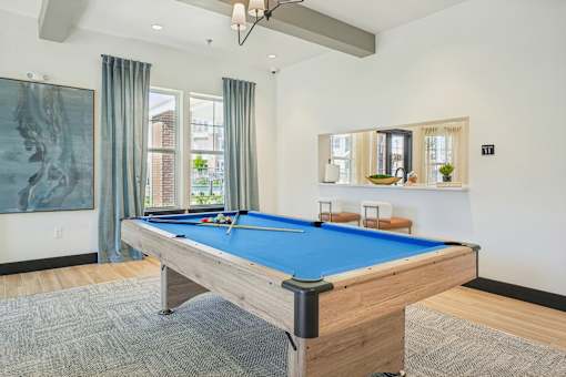 A pool table in a room with a painting on the wall.