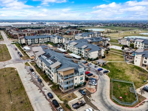 an aerial view of an apartment complex with cars parked in front of it