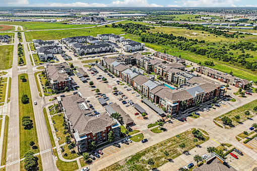 A bird's eye view of a residential area with multiple houses and cars.