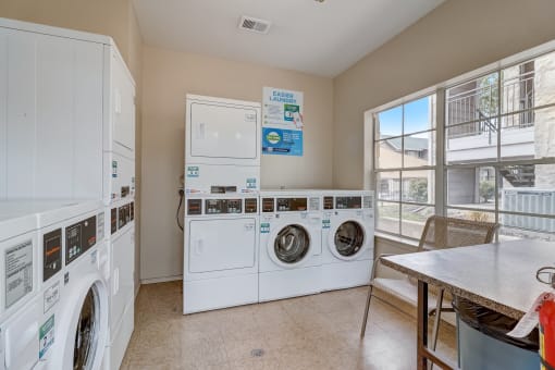 a laundry room with washer and dryer and a table with chairs