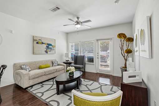 A living room with a couch, coffee table, and a painting on the wall.
