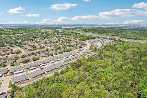 A bird's eye view of a residential area with houses surrounded by greenery.