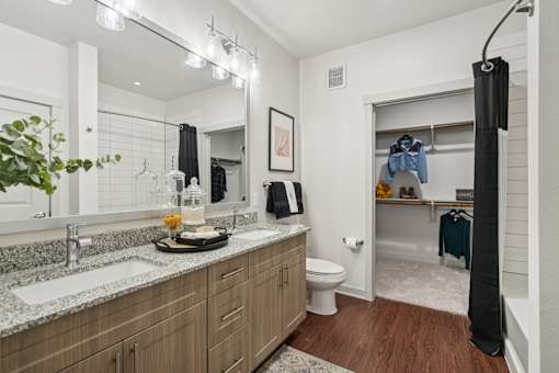 A bathroom with a wooden vanity and a mirror above it.