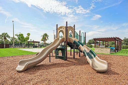 A playground with a green and tan slide.