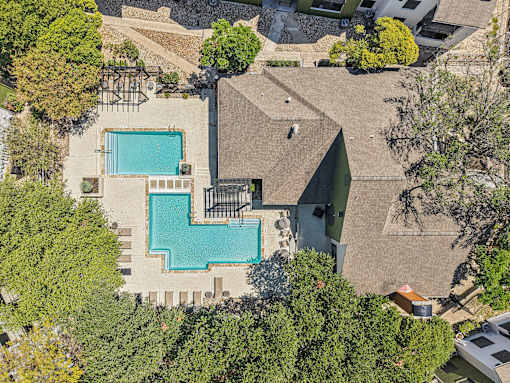A large house with a pool surrounded by trees.