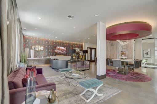 a living room with a pink couch and a dining room table and a kitchen