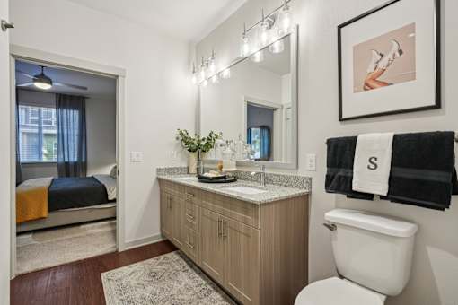 A bathroom with a toilet, sink, and bed.