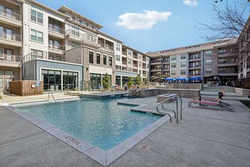 A swimming pool in front of apartment buildings.