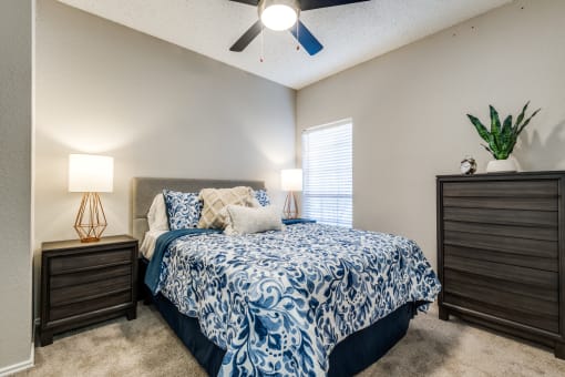 the master bedroom has a comfy bed and a ceiling fan