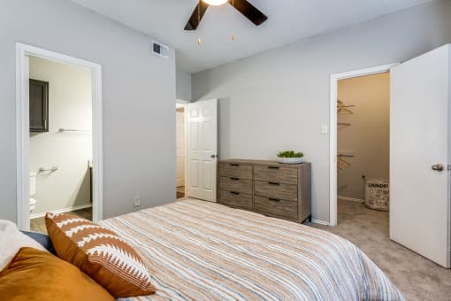 a bedroom with a bed and a closet and a bathroom