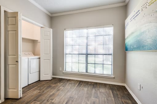 an empty kitchen with a large window and a door to a laundry room