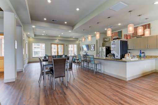 A kitchen with a dining table and chairs.
