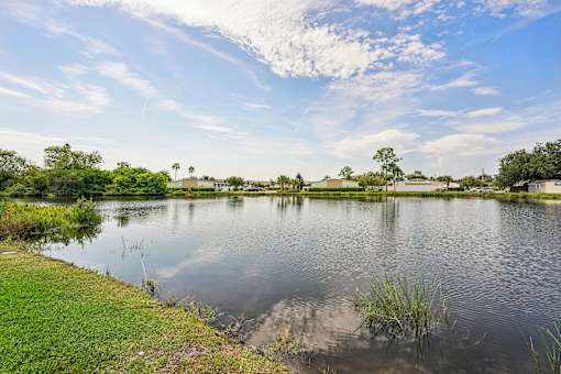 A serene lake surrounded by lush greenery under a clear blue sky.