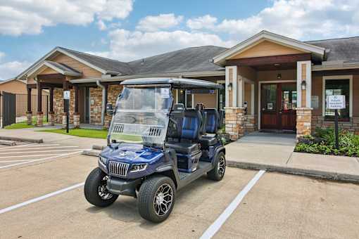 A blue golf cart is parked in front of a building with a sign on it.