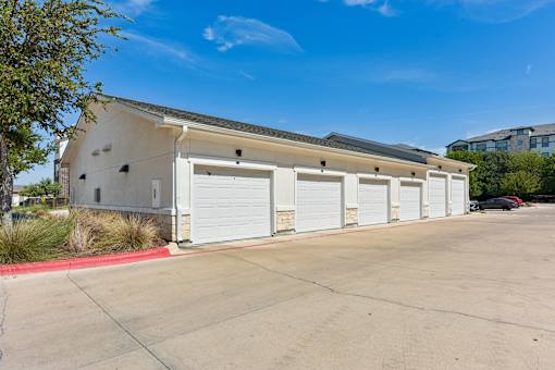 A building with a white garage door is in the foreground.