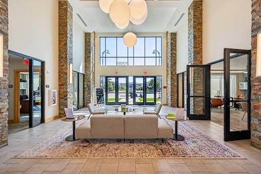 A hallway with a large rug and a couch.