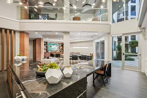 A modern kitchen with a marble countertop and a glass balcony.
