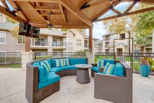 a covered patio with couches and a table