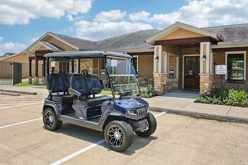 A blue golf cart is parked in front of a building.