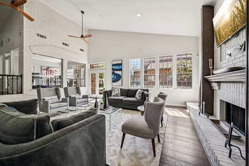 A living room with grey couches and a fireplace.