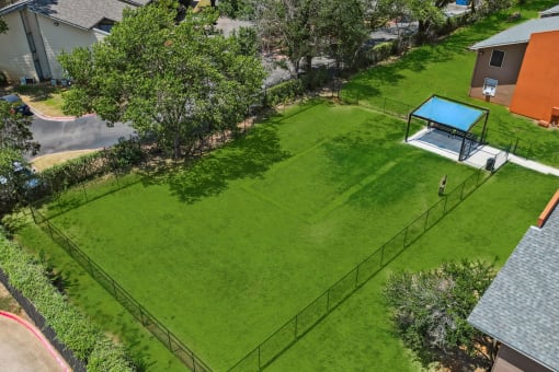 an aerial view of a backyard with a tennis court and basketball court