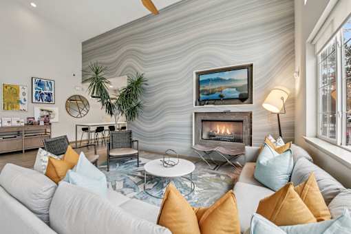 A living room with a white couch and a fireplace.