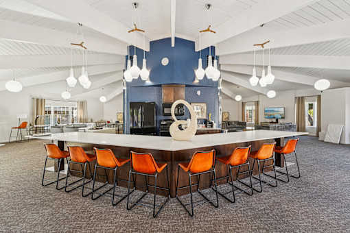 A large conference room with a long table and orange chairs.