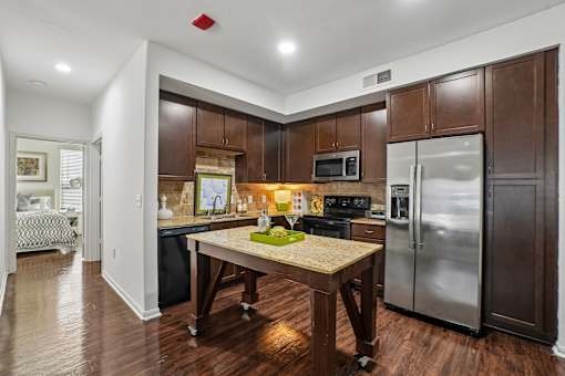 A kitchen with a table and a fridge.