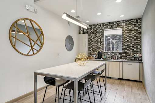 A kitchen with a table and chairs.