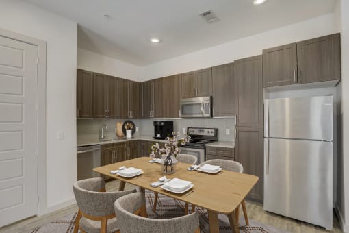 a kitchen with stainless steel appliances and a wooden table