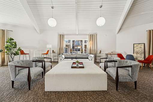 A room with a white table and chairs with a carpet on the floor.