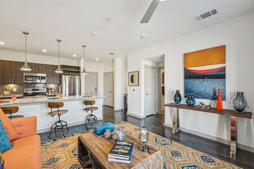 A living room with a kitchen area in the background.