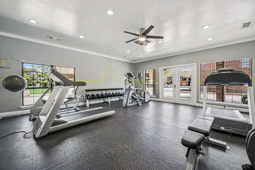 A spacious home gym with a treadmill, weights, and exercise equipment.