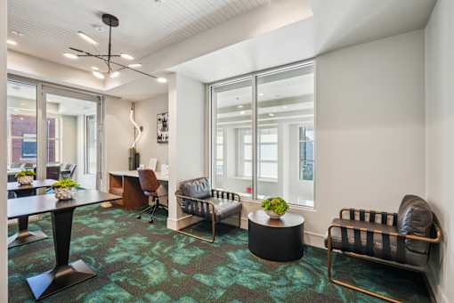 A modern office space with a green carpet and black and gold furniture.