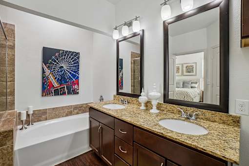 A bathroom with a large mirror and a painting on the wall.