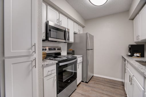 a kitchen with stainless steel appliances and white cabinets