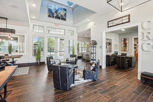 A spacious lobby with a wooden floor and a variety of seating options.