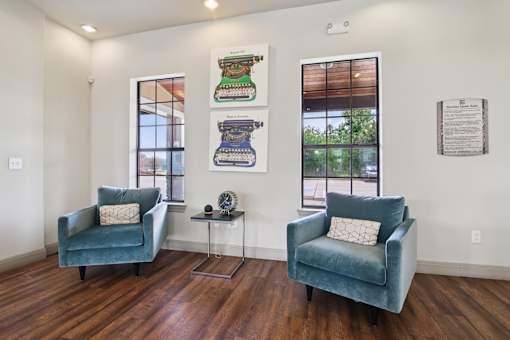 Two chairs and a table are in a room with a window.