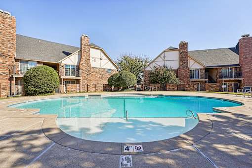 A swimming pool surrounded by a brick building.