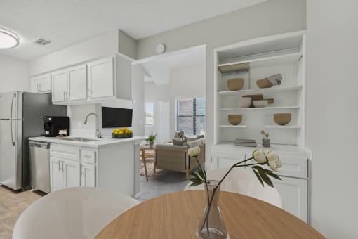 a kitchen and dining room with white cabinets and appliances and a wooden table