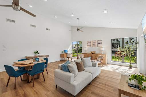 A living room with a couch, chairs, and a dining table.