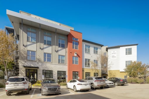 an apartment building with cars parked in front of it