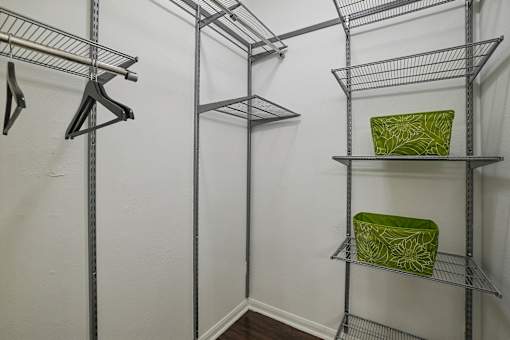 A white wall with a shelf and a green bag on it.