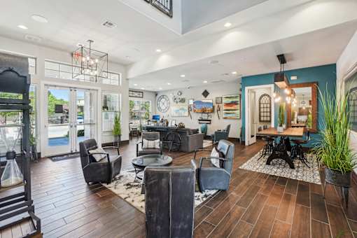 A large, well-lit living room with a variety of seating options and a wooden floor.