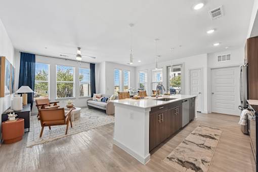 A modern kitchen with a white island and wooden floors.