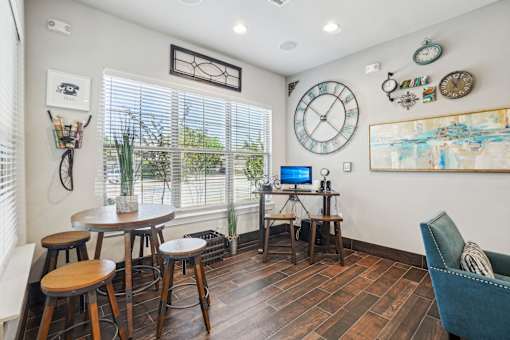 A room with a table, chairs and a painting on the wall.
