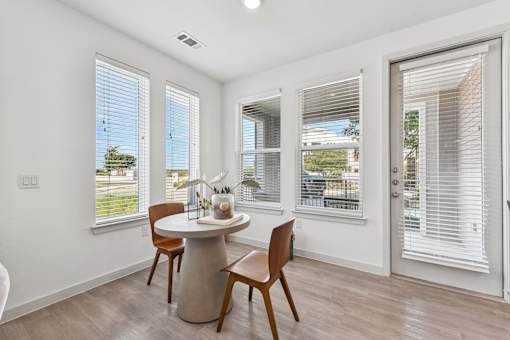 A dining room with a table and chairs.