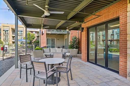 A patio with a table and chairs under a roof.