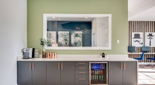 A kitchen with a green wall and a white counter.