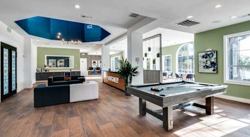 A room with a pool table and a billiard table.